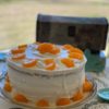 yellow layer cake with crunchy layer topping and creamy frosting. garnished with mandarin oranges.