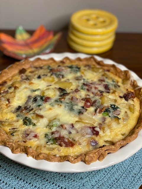 quiche filled with kale, bacon, onions, potatoes and cheese